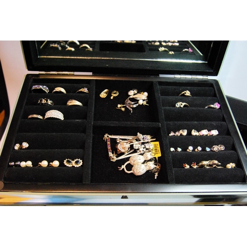 29 - Quantity of silver rings, pendants and other items in mirrored jewel cabinet.