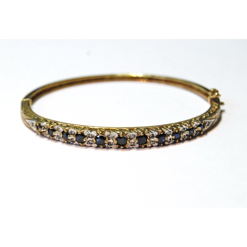 31 - 9ct gold hinged bangle with diamonds and sapphires, 11.9g.