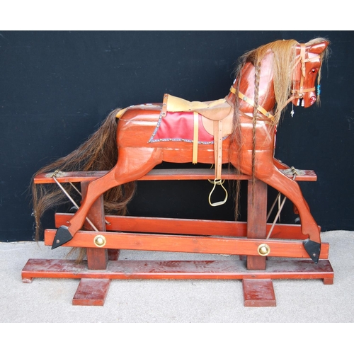 350 - Rocking horse with mane, tail, saddle and tack, raised on cruciform base, by Neil Jackson.