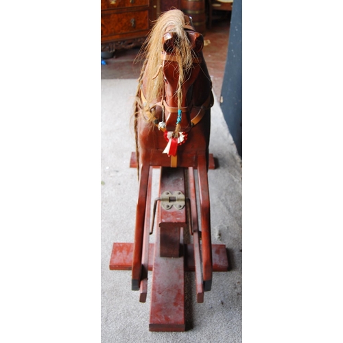 350 - Rocking horse with mane, tail, saddle and tack, raised on cruciform base, by Neil Jackson.