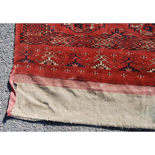 354 - Afghan rug with three rows of three guls and stars over red ground and border, 150cm x 107cm.