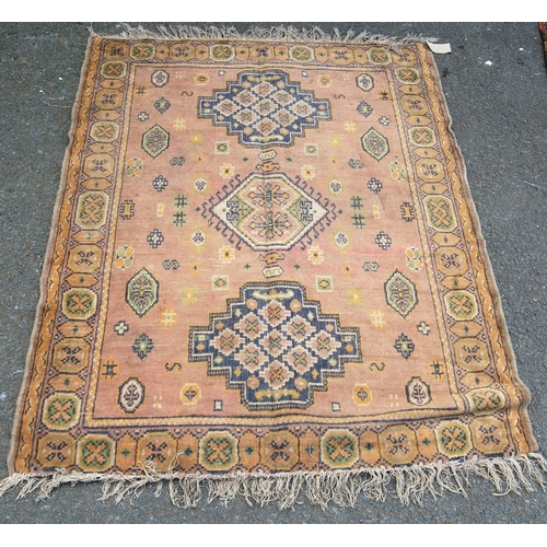 355 - Eastern rug with triple medallions over pink ground, rosettes and border, 157cm x 115cm.