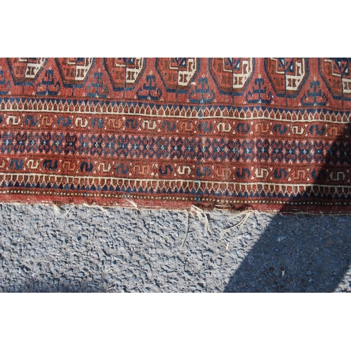 357 - Afghan rug with two rows of ten guls over red ground and geometric border, 135cm x 93cm.