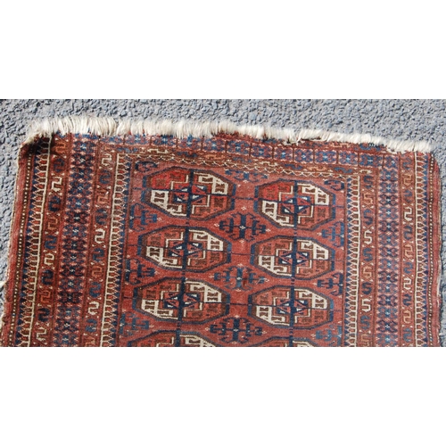 357 - Afghan rug with two rows of ten guls over red ground and geometric border, 135cm x 93cm.