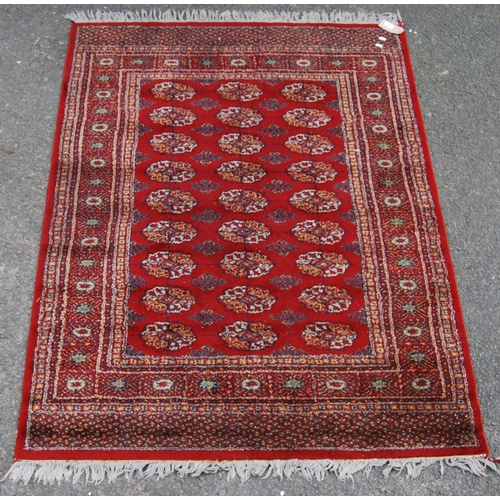 359 - Afghan style machine rug with three rows of nine guls over red ground and border, 173cm x 130cm.