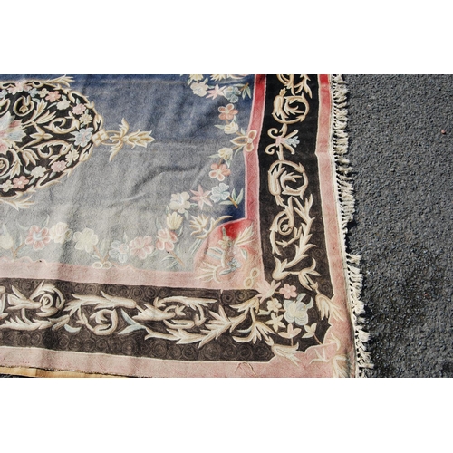 386 - Eastern rug with central floral lozenge over faded blue ground, black and pink floral border, 270cm ... 