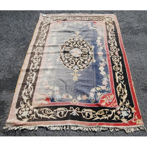 386 - Eastern rug with central floral lozenge over faded blue ground, black and pink floral border, 270cm ... 