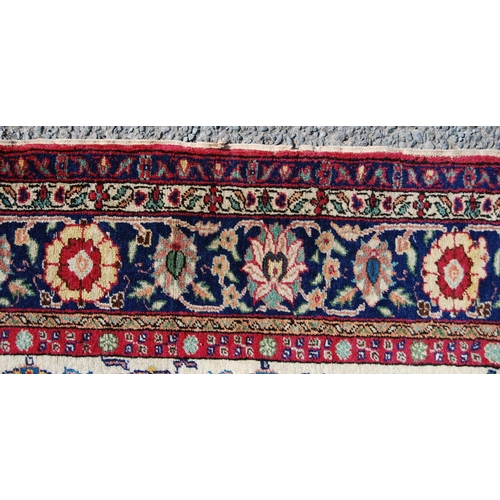 388 - Persian rug with five rows of eleven alternating rosettes over cream ground, floral red and blue bor... 