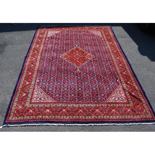 389 - Persian carpet with central red diamond over blue ground, all over geometric floral design, spandrel... 