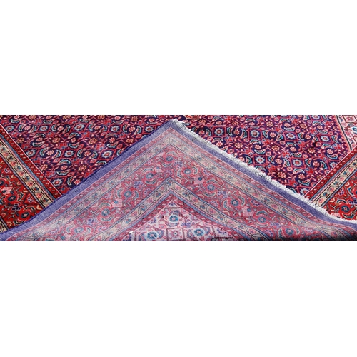 389 - Persian carpet with central red diamond over blue ground, all over geometric floral design, spandrel... 