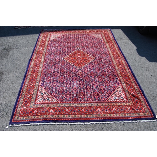 389 - Persian carpet with central red diamond over blue ground, all over geometric floral design, spandrel... 