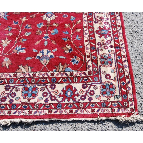 390 - Persian style carpet with all over floral design over red ground and alternate cream floral borders,... 