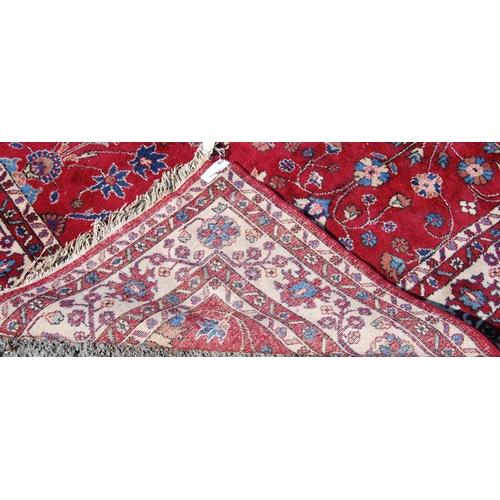 390 - Persian style carpet with all over floral design over red ground and alternate cream floral borders,... 