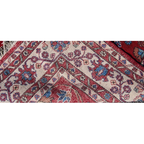 390 - Persian style carpet with all over floral design over red ground and alternate cream floral borders,... 