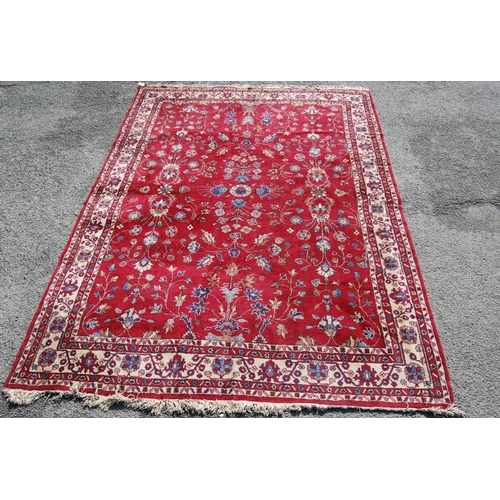 390 - Persian style carpet with all over floral design over red ground and alternate cream floral borders,... 