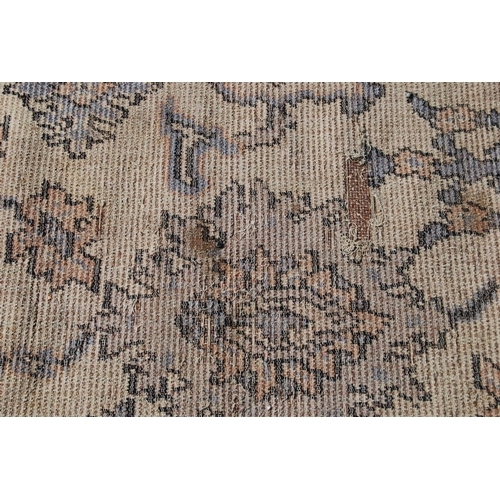 392 - Ushak design rug with foliate design over worn cream ground and faded blue border, 315cm x 115cm.