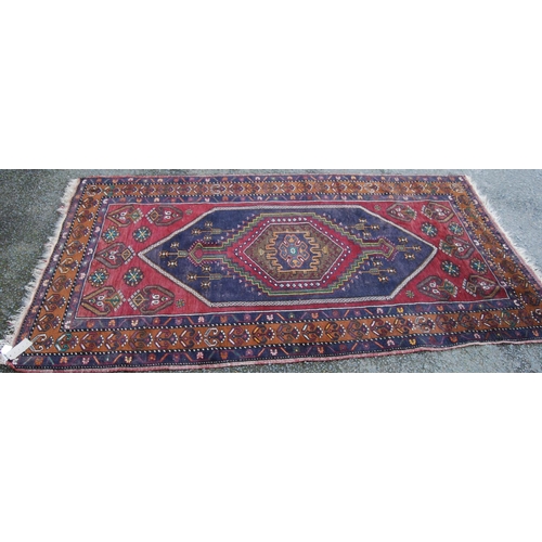 393 - Anatolian rug with central hexagonal medallion, blue diamond field, red ground with geometric floral... 