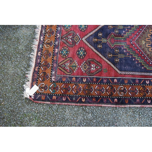 393 - Anatolian rug with central hexagonal medallion, blue diamond field, red ground with geometric floral... 