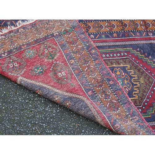 393 - Anatolian rug with central hexagonal medallion, blue diamond field, red ground with geometric floral... 