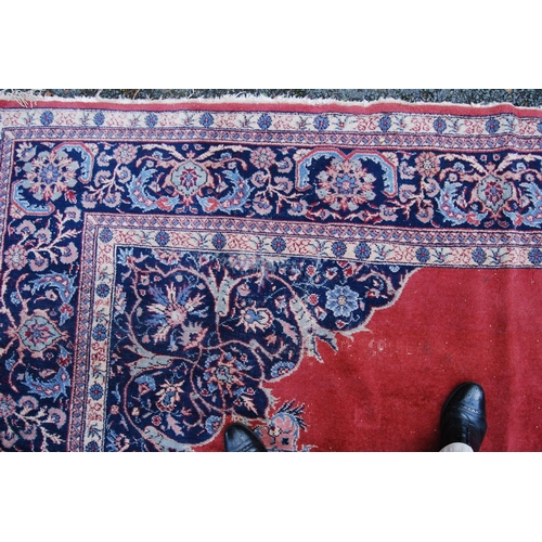 396 - Persian style carpet with central medallion over red ground, spandrels and foliate border, 303cm x 4... 