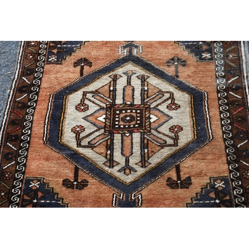 403 - Persian rug with central medallion over brown ground, spandrels and floral border, 138cm x 78cm.