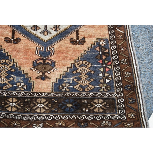 403 - Persian rug with central medallion over brown ground, spandrels and floral border, 138cm x 78cm.