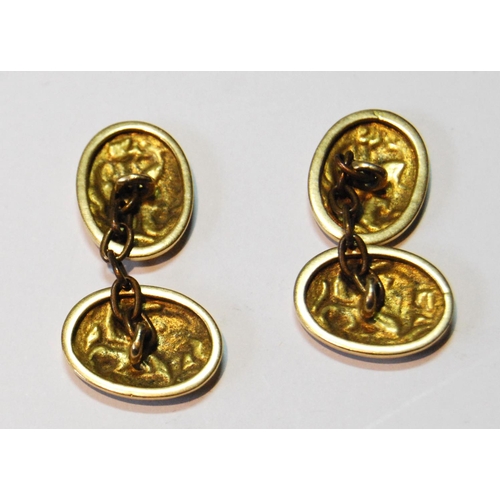 91 - Pair of Chinese gold cufflinks, oval, embossed with figures, now with brass chains, gross 8.7g.