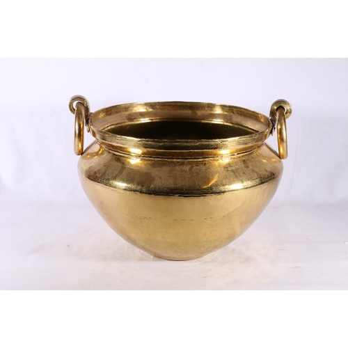 306 - Brass jardiniere of pot form with twin ring handles and incised band decoration, 41cm across the han... 