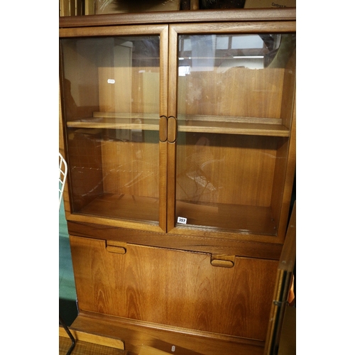 357 - Mid century teak cabinet on stand, glazed doors over fall-flap enclosing glass shelves, stepped base... 