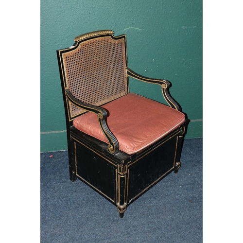 526 - 19th century ebonised commode chair with bergere back and seat, reeded scroll arms and raised on pan... 