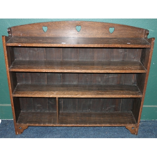 565 - Arts and Crafts oak open bookcase, the gallery bask with pierced heart shaped apertures above four s... 