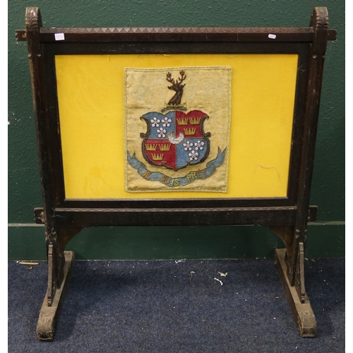 568 - Arts and Crafts oak trestle fire screen wit inset bead work panel depicting Clan Fraser crest with 