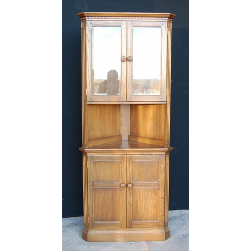 330 - Ercol corner cupboard, the projected moulded cornice over glazed doors, open shelf, panelled doors a... 