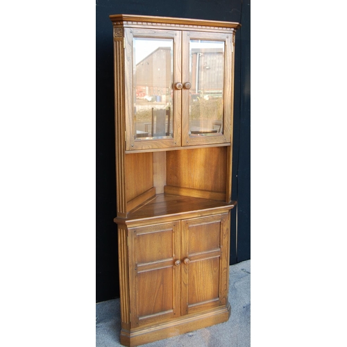 330 - Ercol corner cupboard, the projected moulded cornice over glazed doors, open shelf, panelled doors a... 