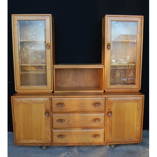 331 - Ercol sideboard cabinet with central open shelf flanked by glazed doors, rectangular top, three long... 