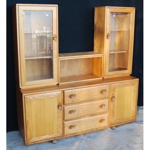 331 - Ercol sideboard cabinet with central open shelf flanked by glazed doors, rectangular top, three long... 