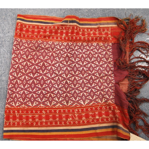 338 - Shawl with geometric design, red ground and border, 120cm x 61cm.