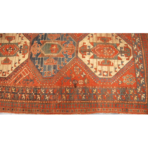 341 - Kazak rug with triple medallions over red ground and star border, 202cm x 132cm.