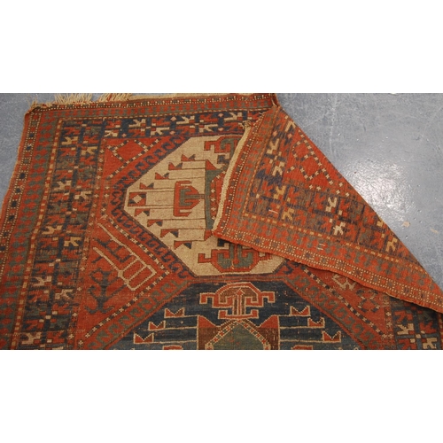 341 - Kazak rug with triple medallions over red ground and star border, 202cm x 132cm.