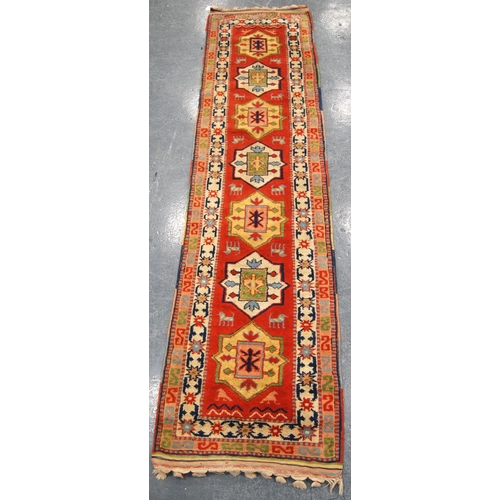 342 - Turkey runner with seven medallions over orange ground and double border, 300cm x 74cm.