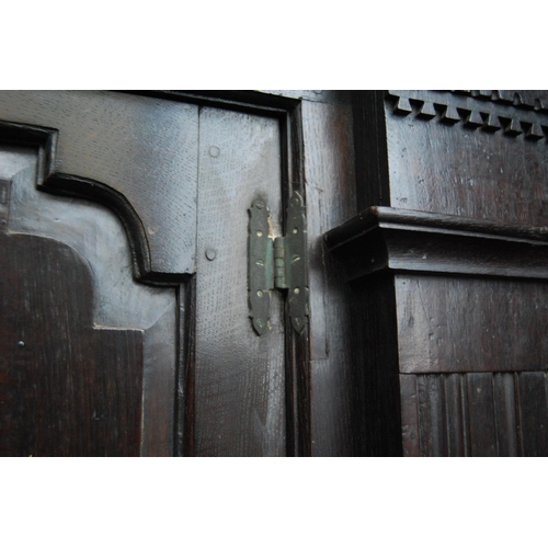 370 - Oak hall cupboard, the projected moulded cornice over panelled doors, fluted columns, stepped base, ... 