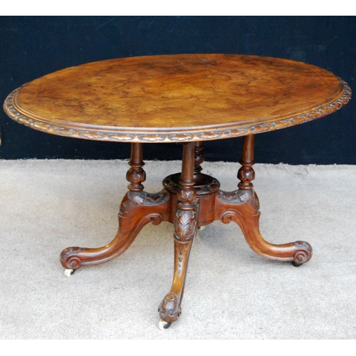 377 - Victorian walnut loo table with oval inlaid top, floral carved moulding, raised on baluster quad col... 