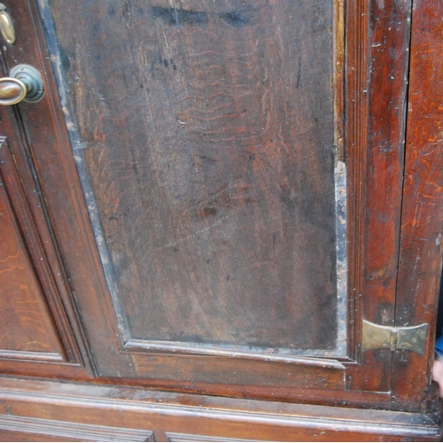 384 - Georgian oak hall cabinet, the projected moulded cornice over panelled doors over stepped base with ... 