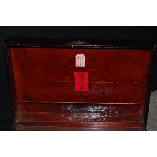 385 - Oriental lacquered trunk of rectangular form enclosing a shelf, 63cm wide, 34cm high and 42cm deep.