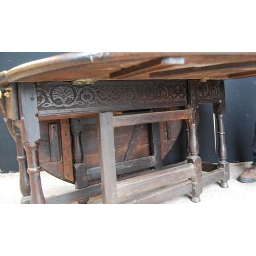 387 - Oak gate-leg table, the oval top raised on baluster turned legs united by stretchers terminating in ... 