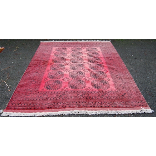 391 - Afghan carpet with three rows of six guls over red ground, multiple borders, 300cm x 204cm.