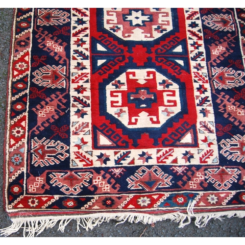 393 - Turkish rug with three cruciform octagonal panels, star and floral triple border, 120cm x 93cm.