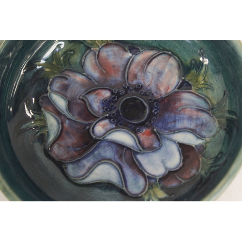 31 - Moorcroft Pottery Anemone pattern circular footed dish with green ground. 11.5cm dia, paper label...