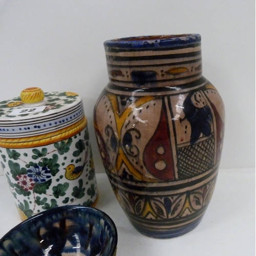 22 - Continental decorated vase, a similar jar and cover and a blue glazed small bowl (3)