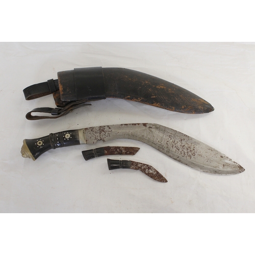 99 - Two Antique Nepalese Kukris, one in curved leather scabbard with two smaller blades, inlaid handles ... 